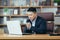 Businessman worried about business, sad and frustrated sitting in the office, looking anxiously at the laptop screen