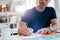 Businessman writing down important notes in diary at his desk