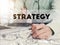 Businessman writing financial strategy graph report on desk