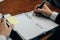 businessman writing on paper at workplace. young male entrepreneur man handwriting note at office. paperwork on table.