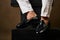 Businessmans foot wearing black leather shoes and white jeans, close-up