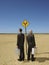 Businessmen With Briefcases Standing By Road Sign In Desert