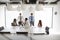 Businessmen And Businesswomen Meeting Around Table In Modern Boardroom