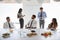 Businessmen And Businesswomen Meeting In Modern Boardroom Over Working Lunch