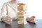 Businessmen carefully placed wooden blocks in a high tower, Protecting a tall wooden tower also involves a high risk