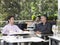 Businessmen Conversing At Outdoor Cafe