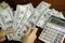 Businessmen counting money on a stack of 100 US dollars banknotes