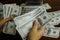 Businessmen counting money on a stack of 100 US dollars banknotes