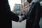 Businessmen Do Handshake With Partner In Front Of Defocused Business Center. Generative AI