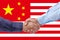 Businessmen handshaking on Usa or American and China flags merged relationship concept