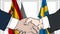 Businessmen or politicians shake hands against flags of Spain and Sweden. Official meeting or cooperation related