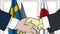 Businessmen or politicians shake hands against flags of Sweden and Japan. Official meeting or cooperation related