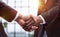 Businessmen reach out to each other to shake hands