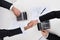 Businessmen Shaking Hands While Calculating Finance At Desk