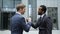 Businessmen shaking hands, multiracial friendship, teamwork, support in startup