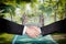 Businessmen shaking hands with a small curved wooden bridge in t