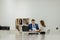 Businessmen smile talking to businesswoman colleague, businesspeople executive secretary and boss at desk in office boardroom