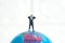 Businessmen standing using binoculars above earth globe. Miniature tiny people toys photography.  on white background