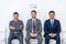 Businessmen in suits sitting on chairs at white waiting room