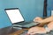 Businessmen use laptop to find information on working with vintage blue backdrops in coffee shop