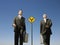 Businessmen Walking Past Road Sign