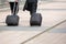 Businessmen walking with wheeled luggage