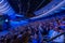 Businesspeople attending global seminar in illuminated blue auditorium