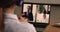 Businesspeople involved in group videocall, laptop screen over businesswoman shoulder