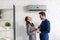 Businesspeople laughing while standing under air conditioner in office