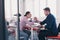 businesspeople, rivalry and people concept - businesswoman and businessman arm wrestling during corporate meeting in