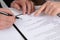 Businesspeople signing contract at white table, closeup of hands