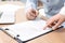 Businesspeople signing contract at wooden table, closeup