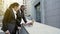 Businesspeople standing in street with laptop, talking, negotiations preparation