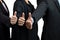 Businesspeople teamwork in black suit showing OK approve or like signal with thumb raise up