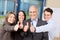 Businesspeople With Thumbs Up Sign In Office