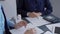 Businesspeople working at a grey glass table. Two accountants or auditors are using a calculator for counting taxes or