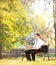 Businessperson on bench working on a laptop in a park