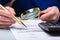 Businessperson Checking Bill Through Magnifying Glass