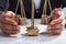 Businessperson Covering Stacked Coins On Weighing Scale