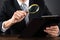 Businessperson Inspecting Document With Magnifying Glass