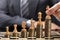 Businessperson Placing Chess Pieces On Stacked Coins