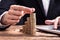 Businessperson Placing A Coin On Increasing Coin Stacks