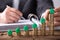 Businessperson Placing House Model On Increasing Stacked Coins