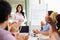 Businesswoman Addressing Meeting Around Boardroom Table