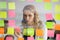 Businesswoman attaching to wall colorful sticky notes with tasks