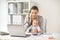 Businesswoman with baby calling on phone at office