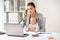 Businesswoman with baby calling on phone at office