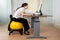 Businesswoman Bending While Sitting On Fitness Ball