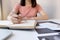 Businesswoman bookkeeper hand note analysis the graph with calculator and laptop at the home office for setting challenging