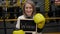 A businesswoman in a boxing gloves holds a board with the inscription WINNER.